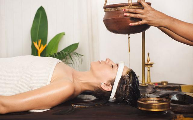 Shirodhara - A person receiving a traditional Ayurvedic treatment with oil pouring on the forehead